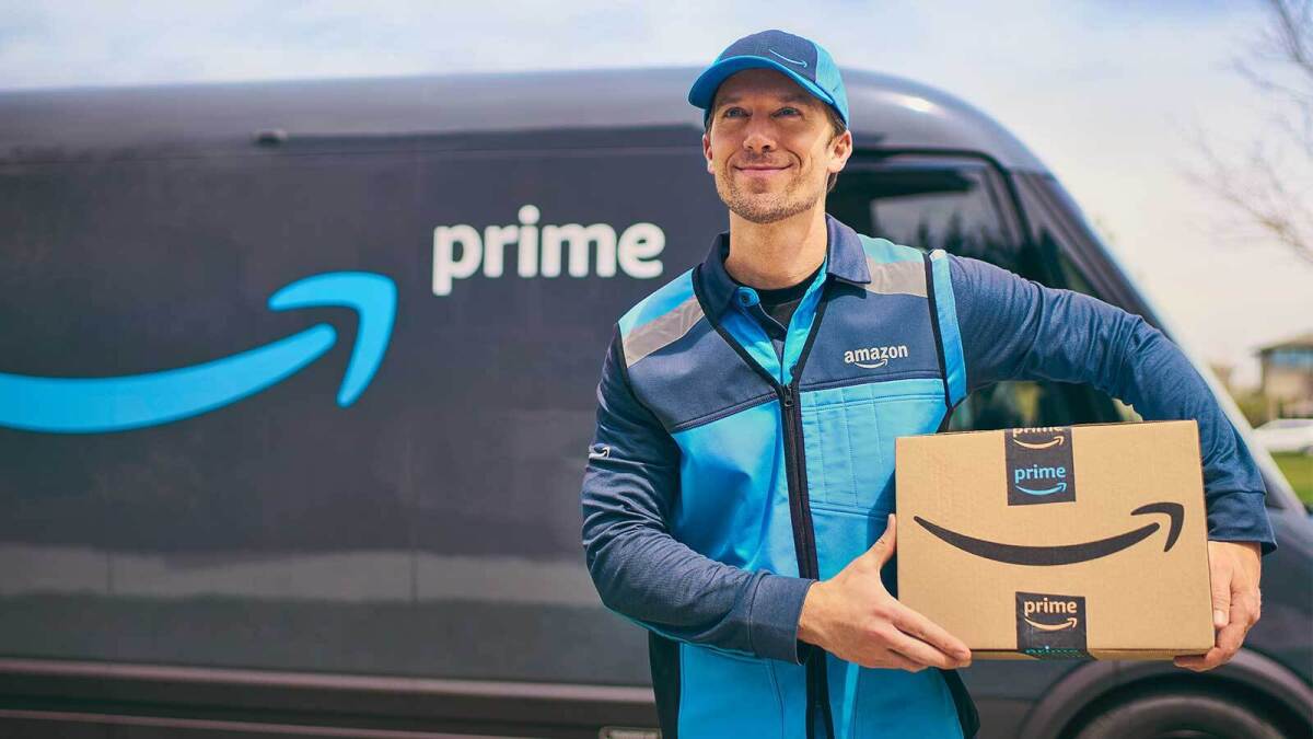 Repartidor de Amazon Prime sosteniendo un paquete frente a una furgoneta con logo de Prime. Imagen usada en Mundo Chido para ilustrar los beneficios de Amazon Prime.